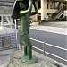 A sculpture of a girl under a big leaf in a rain